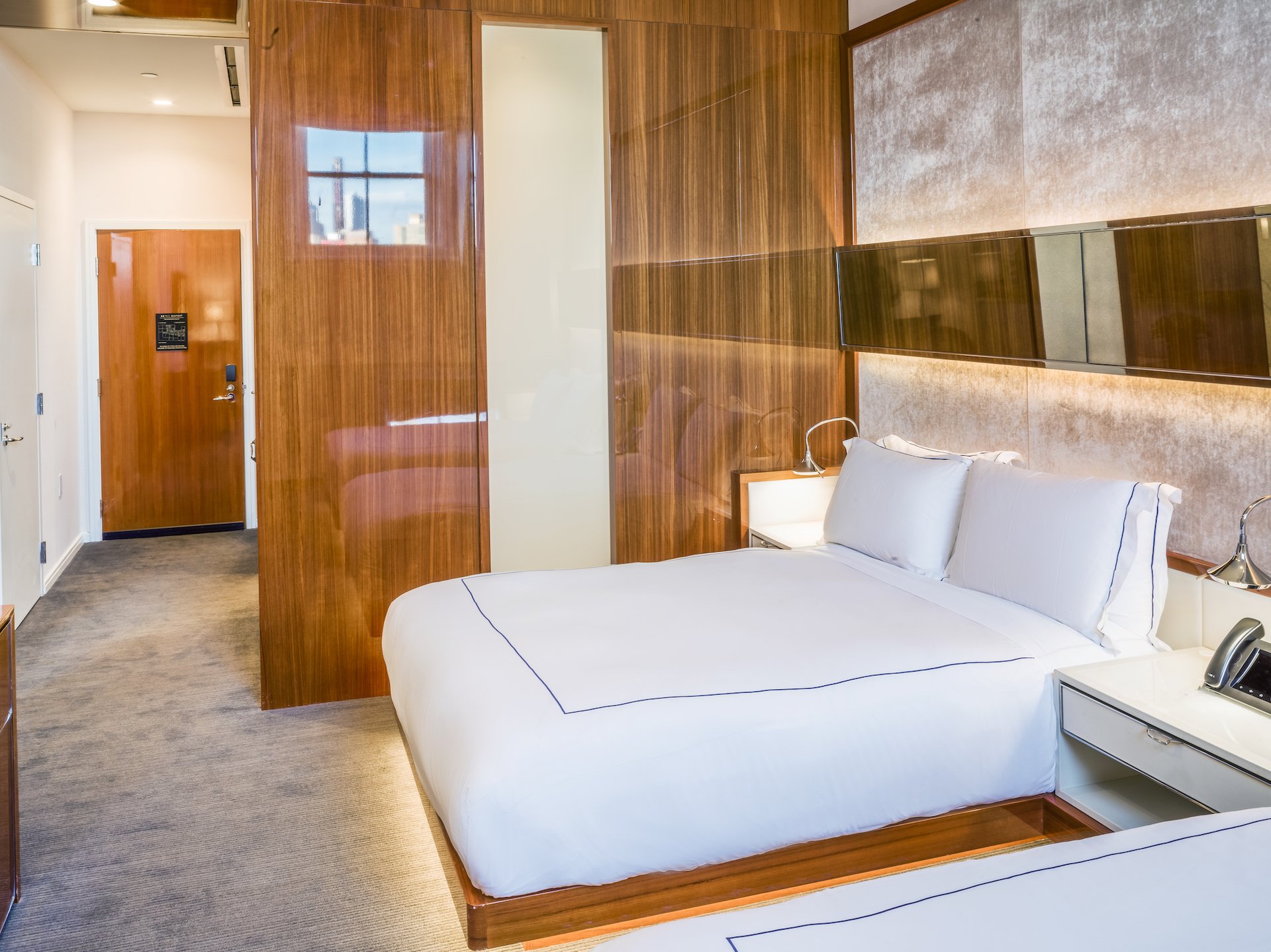 room with two queen beds and wooden accent wall